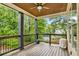 Back porch with ceiling fan, dark wood beams and rails, overlooking green trees and grass at 374 Beaumont Farms Dr, Sharpsburg, GA 30277