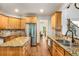 Bright kitchen features wood cabinetry, granite countertops, stainless steel appliances, and center island at 374 Beaumont Farms Dr, Sharpsburg, GA 30277