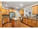 Kitchen with wood cabinets, granite countertops, stainless steel appliances, and a center island at 374 Beaumont Farms Dr, Sharpsburg, GA 30277