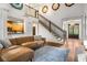 Spacious living room with high ceilings, a cozy leather couch, and hardwood floors creating a warm and inviting atmosphere at 374 Beaumont Farms Dr, Sharpsburg, GA 30277