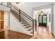 Elegant staircase with wood treads, wrought iron railings, and modern chandelier adding a touch of sophistication at 374 Beaumont Farms Dr, Sharpsburg, GA 30277