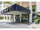 Elegant building entrance at 620 Peachtree Street with awning, plants, and glass doors at 620 Peachtree Ne St # 1111, Atlanta, GA 30308