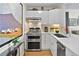 Modern kitchen with stainless steel appliances, sleek white cabinetry, and stone backsplash at 620 Peachtree Ne St # 1111, Atlanta, GA 30308