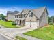 Two-story home with tan siding, brick accents, and attached two-car garage with well-manicured lawn at 766 Chapman St, Jonesboro, GA 30238