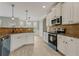 Open kitchen with white cabinets, dark countertops, stainless-steel appliances, and breakfast bar at 766 Chapman St, Jonesboro, GA 30238