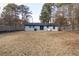 Spacious backyard surrounded by trees with a white brick house in the background at 935 Conley Se Rd, Atlanta, GA 30354