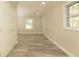A bright bedroom featuring stylish wood-look flooring, neutral paint, and natural light at 935 Conley Se Rd, Atlanta, GA 30354