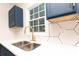 Close-up of kitchen sink area featuring white countertops, unique backsplash, and modern faucet at 935 Conley Se Rd, Atlanta, GA 30354