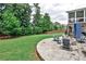Landscaped backyard featuring stone patio with fire pit and mature trees at 148 Sierra Cir, Woodstock, GA 30188