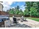 Backyard stone patio with seating, firepit, hot tub, and mature trees at 148 Sierra Cir, Woodstock, GA 30188