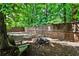 Wood-fenced backyard featuring a fire pit, mature trees, and natural setting at 148 Sierra Cir, Woodstock, GA 30188
