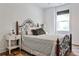 Cozy bedroom featuring an iron bed frame, wood floors, and a light-filled window at 148 Sierra Cir, Woodstock, GA 30188