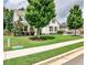 View of a two-story home with manicured lawn, trees, and sidewalk in front at 148 Sierra Cir, Woodstock, GA 30188