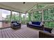 Inviting screened porch with comfortable wicker furniture and peaceful wooded views at 148 Sierra Cir, Woodstock, GA 30188