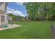 Expansive backyard featuring lush green grass, mature trees, and a patio area, perfect for outdoor entertaining at 250 Lawrence Pl, Atlanta, GA 30349