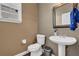 Well-lit half bath featuring a pedestal sink, toilet, and modern fixtures at 250 Lawrence Pl, Atlanta, GA 30349