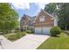 Brick home showcasing a long driveway, manicured lawn, and an attached two-car garage at 250 Lawrence Pl, Atlanta, GA 30349