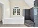 Bright main bathroom with a large window over the garden tub and a modern glass-enclosed tiled shower at 250 Lawrence Pl, Atlanta, GA 30349