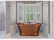 Beautiful bathroom showcasing a luxurious copper soaking tub and bright windows at 325 Edwards Brook Ln, Canton, GA 30115