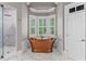 Freestanding copper tub surrounded by windows in a bright bathroom at 325 Edwards Brook Ln, Canton, GA 30115