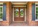 A close-up of the brick home's front door features sidelights and a 'Welcome' mat at 325 Edwards Brook Ln, Canton, GA 30115