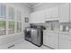 Bright laundry room with white cabinets, sink, and modern washer and dryer at 325 Edwards Brook Ln, Canton, GA 30115