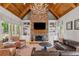 Bright living room with stone fireplace, wood ceiling, built-in bookshelves, and leather sofas at 325 Edwards Brook Ln, Canton, GA 30115
