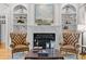 Cozy living room with a fireplace, built-in bookshelves, and tufted leather chairs at 325 Edwards Brook Ln, Canton, GA 30115