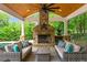 Outdoor fireplace with seating area, ceiling fan, wood ceiling, and views of the backyard at 325 Edwards Brook Ln, Canton, GA 30115