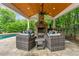 Covered outdoor living area with stone fireplace, comfortable seating, wood ceiling, and a serene view at 325 Edwards Brook Ln, Canton, GA 30115