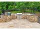 Well-equipped outdoor kitchen featuring a stainless steel grill, stone countertops, and ample preparation space for outdoor cooking at 325 Edwards Brook Ln, Canton, GA 30115