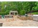 Outdoor kitchen with built-in grill, countertop, and stone surround, adjacent to an outdoor lounge and patio area at 325 Edwards Brook Ln, Canton, GA 30115