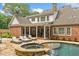 A stunning backyard features a pool with a stone spa, waterfalls, and a patio with lounge chairs at 325 Edwards Brook Ln, Canton, GA 30115