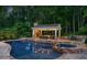 Resort-style pool with a spa, covered outdoor kitchen, and lush green landscaping at 325 Edwards Brook Ln, Canton, GA 30115