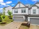 Two story townhome with a gray two car garage, and well landscaped front yard at 359 Crider Ct, Woodstock, GA 30188