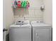 Efficient laundry area with modern washer and dryer, plus organized shelving for cleaning supplies at 359 Crider Ct, Woodstock, GA 30188