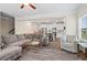 Cozy living room featuring an open concept to the kitchen, gray wood floors, with a comfortable gray sectional and accent chair at 359 Crider Ct, Woodstock, GA 30188
