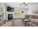 Comfortable living room with gray wood floors, fireplace, large tv, and ample seating with sectional and armchair at 359 Crider Ct, Woodstock, GA 30188