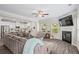 Open-concept living room with gray wood floors, fireplace, and an expansive sectional sofa, adjoined to a modern, bright kitchen at 359 Crider Ct, Woodstock, GA 30188