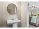 Charming powder room with a pedestal sink and view into the adjacent living room at 359 Crider Ct, Woodstock, GA 30188