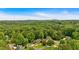 An aerial view shows a wooded neighborhood with mature trees and rolling hills on a sunny day at 3987 Tamarack Nw Dr, Kennesaw, GA 30152