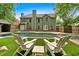 Backyard oasis with chairs, green grass, beautiful pool, lush trees, and exterior view of the home at 3987 Tamarack Nw Dr, Kennesaw, GA 30152