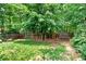 A large private backyard features a mature tree, a wooden swing set and is surrounded by a wooden fence at 3987 Tamarack Nw Dr, Kennesaw, GA 30152