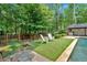 Beautiful backyard with green grass, Adirondack chairs, lush green trees, and view of the home's pool at 3987 Tamarack Nw Dr, Kennesaw, GA 30152