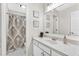 Bright bathroom features white cabinets, a large mirror, decorative art, and a shower with patterned curtain at 3987 Tamarack Nw Dr, Kennesaw, GA 30152