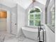 Stylish bathroom featuring a free-standing tub, a modern shower, and a vanity with marble floors at 3987 Tamarack Nw Dr, Kennesaw, GA 30152