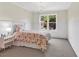 Cozy bedroom features a decorative chandelier, carpet, and a window with a beautiful view of the surrounding nature at 3987 Tamarack Nw Dr, Kennesaw, GA 30152