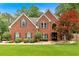 Charming brick home featuring a well-manicured lawn, symmetrical facade, and classic architectural details at 3987 Tamarack Nw Dr, Kennesaw, GA 30152