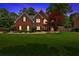 Charming two-story home features a well-manicured lawn, a brick facade, and mature landscaping at 3987 Tamarack Nw Dr, Kennesaw, GA 30152