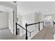 Hallway with neutral walls, plush carpet, black and white banister, and a decorative light fixture at 3987 Tamarack Nw Dr, Kennesaw, GA 30152